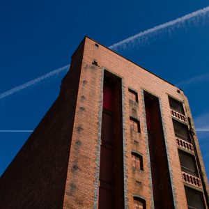 Old red brick warehouse. Liverpool docklands. Vapour trails.